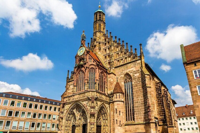 A historic church with intricate architecture, a prominent clock tower, and a clear blue sky. 2