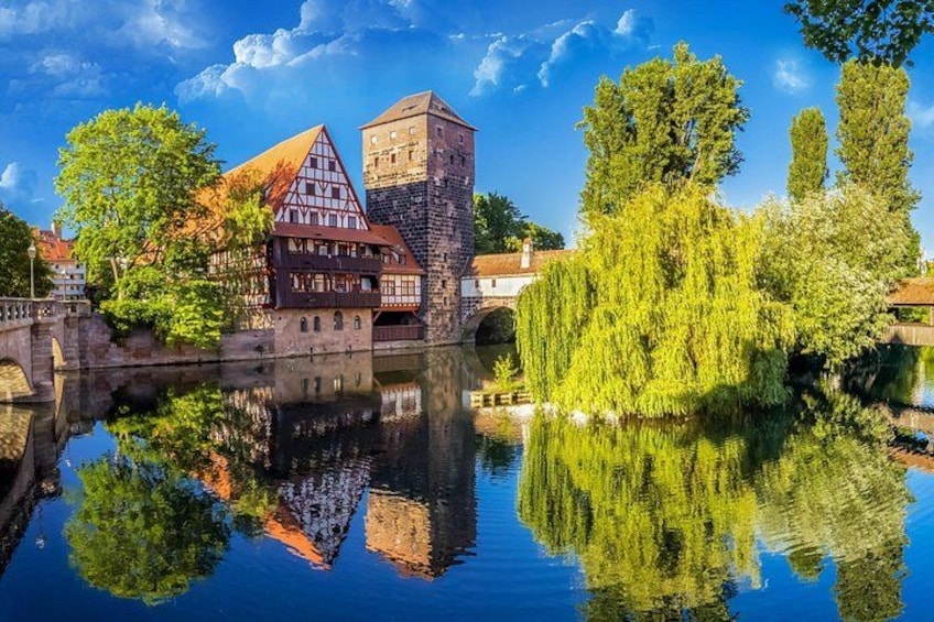 A historic town with a castle, traditional houses, a bridge, and a river reflecting the scenery. 5