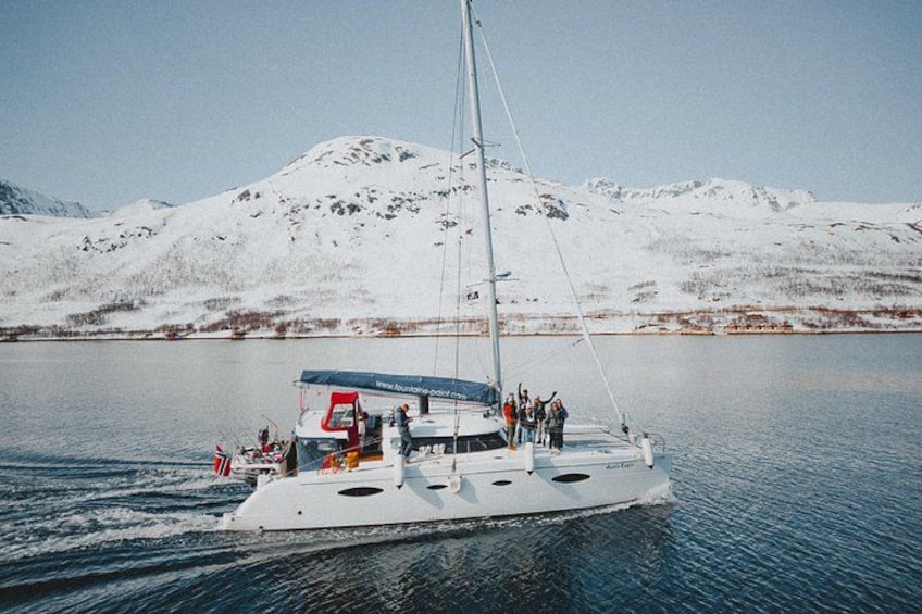 Un voilier sur une étendue d’eau calme, avec une montagne enneigée en arrière-plan. 1