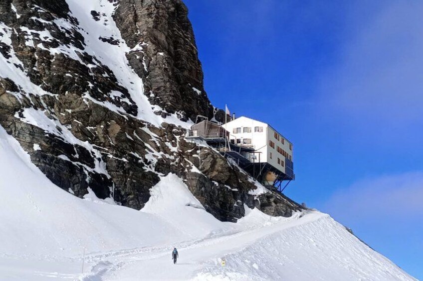 Una montagna innevata con un edificio a strapiombo. 5