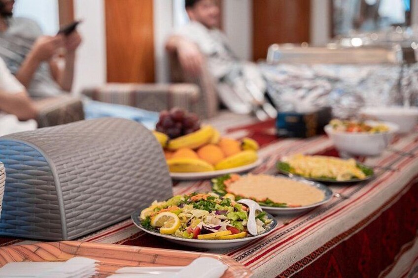 A buffet table with various dishes, including salads, fruits, and a large blue container. 3