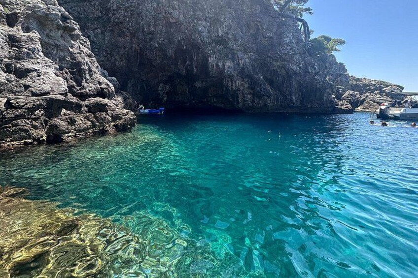 Une mer d’un bleu profond, des falaises rocheuses et un bateau. 5