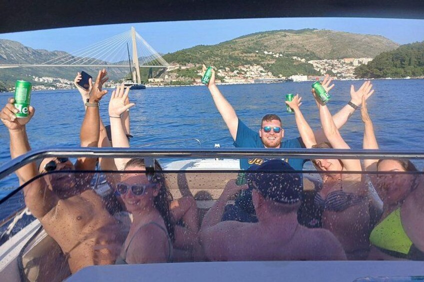 Des personnes se trouvent sur un bateau, avec un pont et des collines en arrière-plan. 4