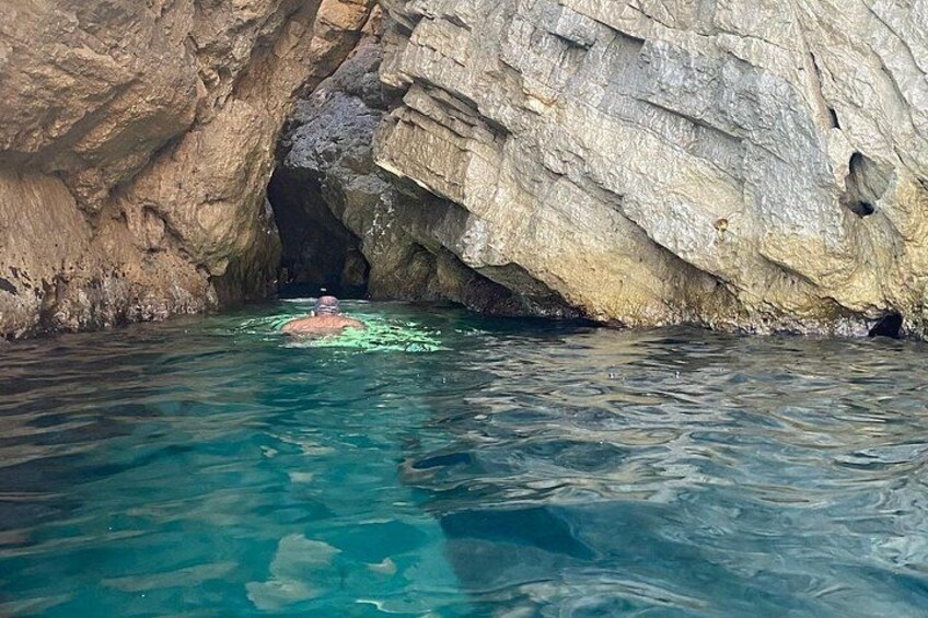 Une personne nage dans une piscine aux eaux bleues et limpides, dont les parois sont rocheuses. 3