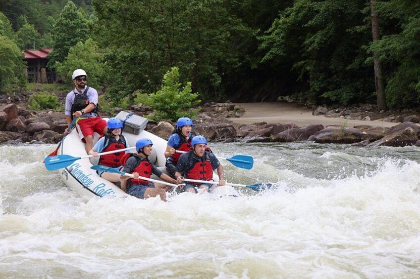 Un grupo de personas en balsas navegando un río rodeado de rocas y árboles. 4