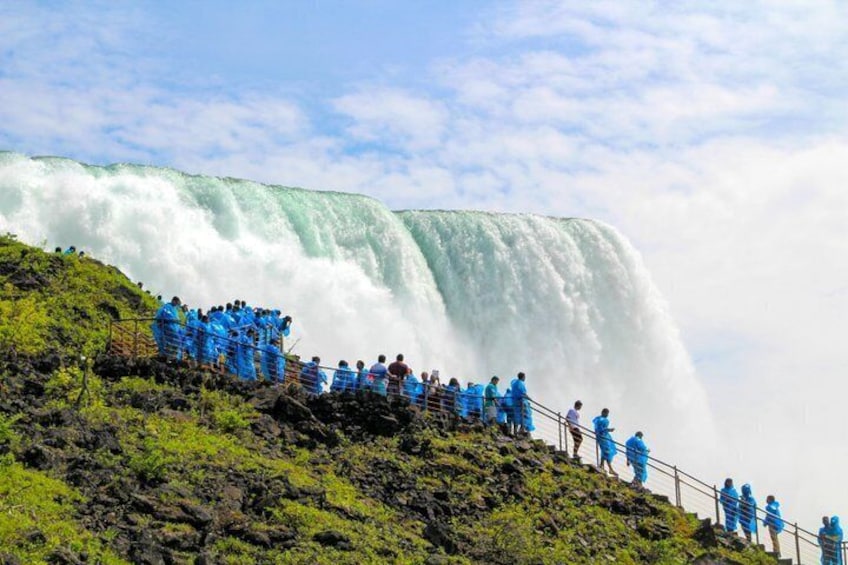 A large waterfall with people standing on a viewing platform. 4