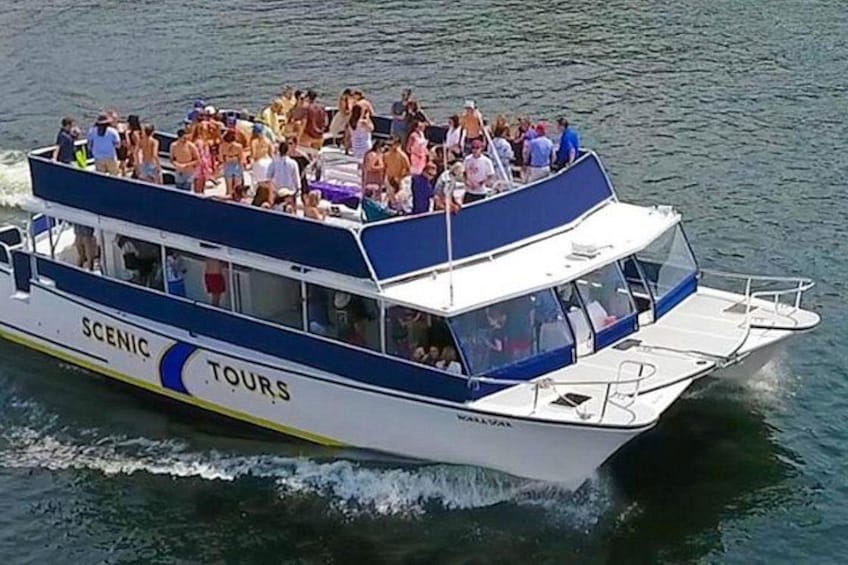 A boat with 'SCENIC TOURS' written on its side, carrying many passengers. 3