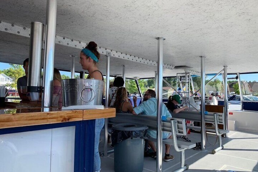 Un espacio cubierto al aire libre con personas comiendo y una barra de servicio. 4