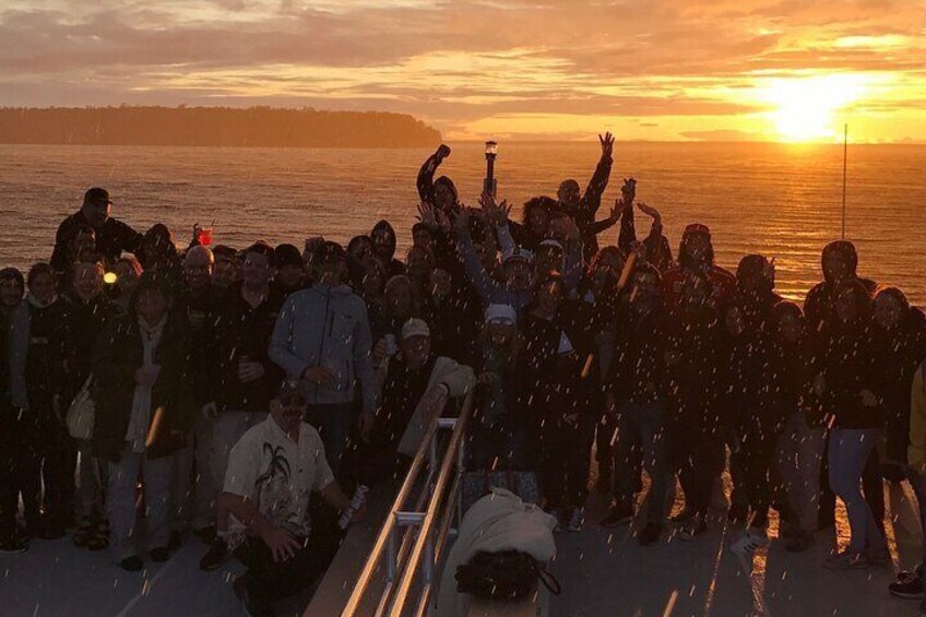 Un grupo de personas en la playa durante el atardecer. 3