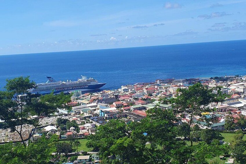 A cruise ship in the ocean, a coastal cityscape with buildings, and a clear blue sky. 2