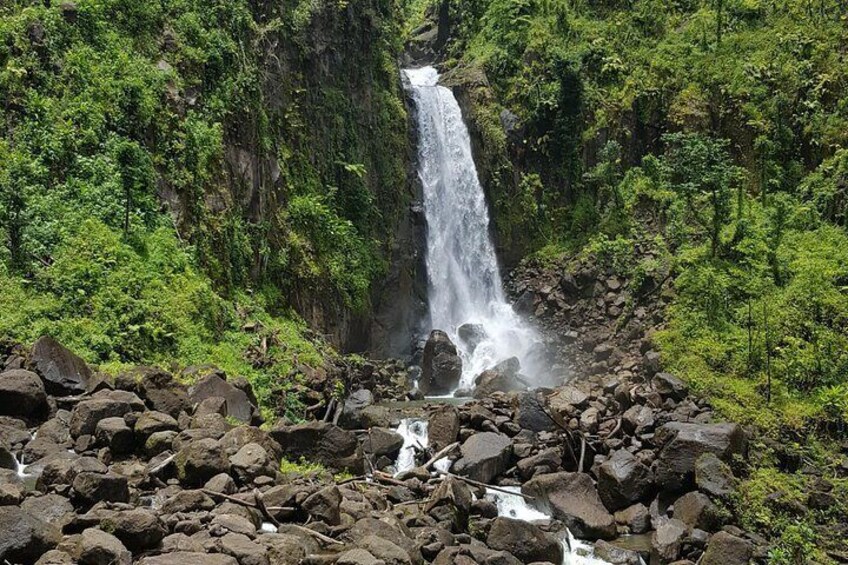 A waterfall surrounded by lush greenery and rocky terrain. 5