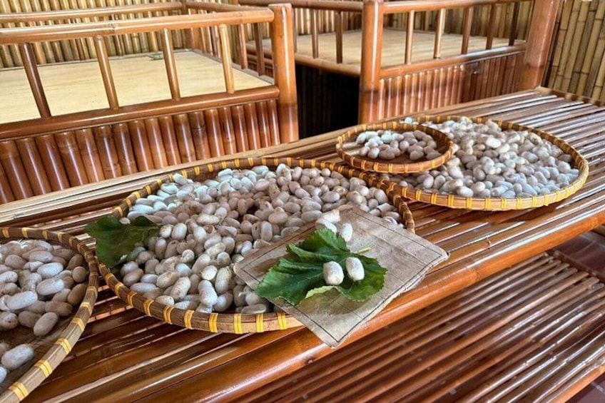 A bamboo structure with woven baskets filled with white stones, placed on a wooden table. 3