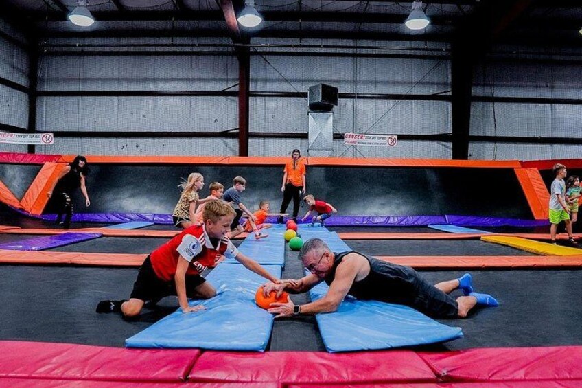 An indoor trampoline park with multiple trampolines and people engaging in activities. 1
