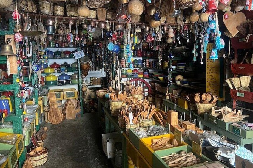 Een rommelige overdekte markt met diverse waren, waaronder manden, houten keukengerei en hangende artikelen. 4