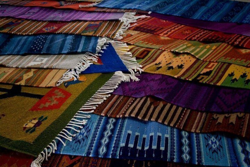 A collection of colorful woven rugs with intricate patterns and fringes. 5