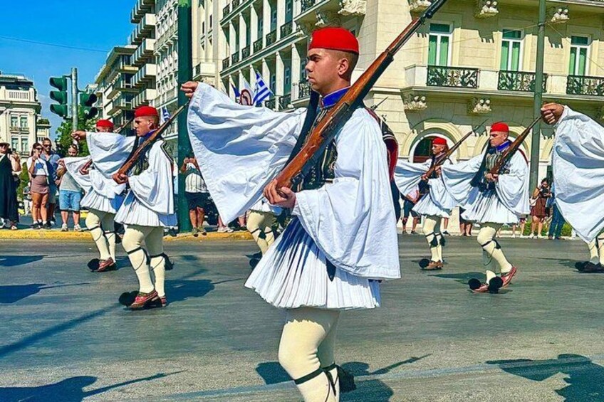 A group of people in traditional white and red attire marching with flags. 3