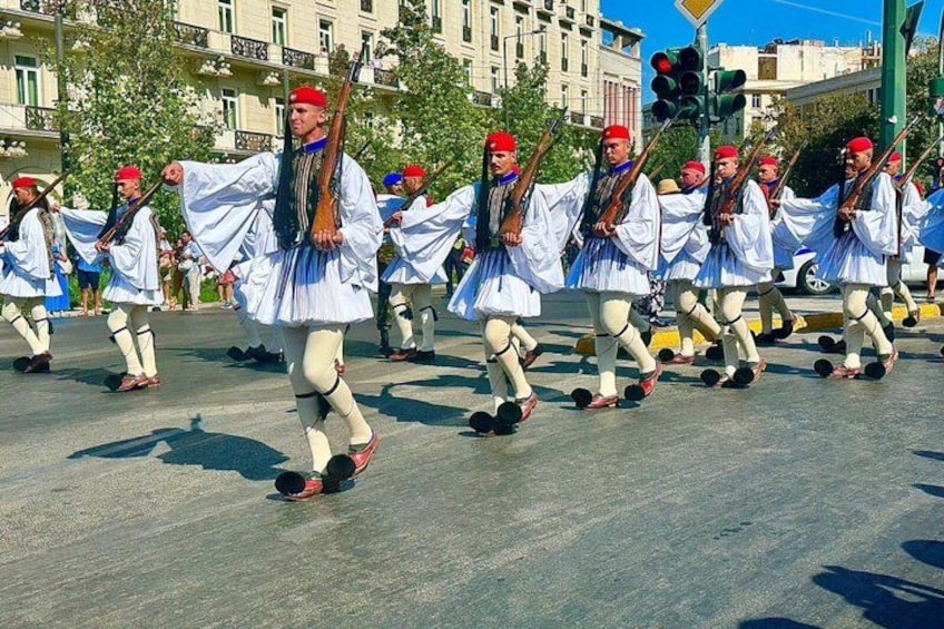 A group of people in traditional white and red attire marching in a parade. 5
