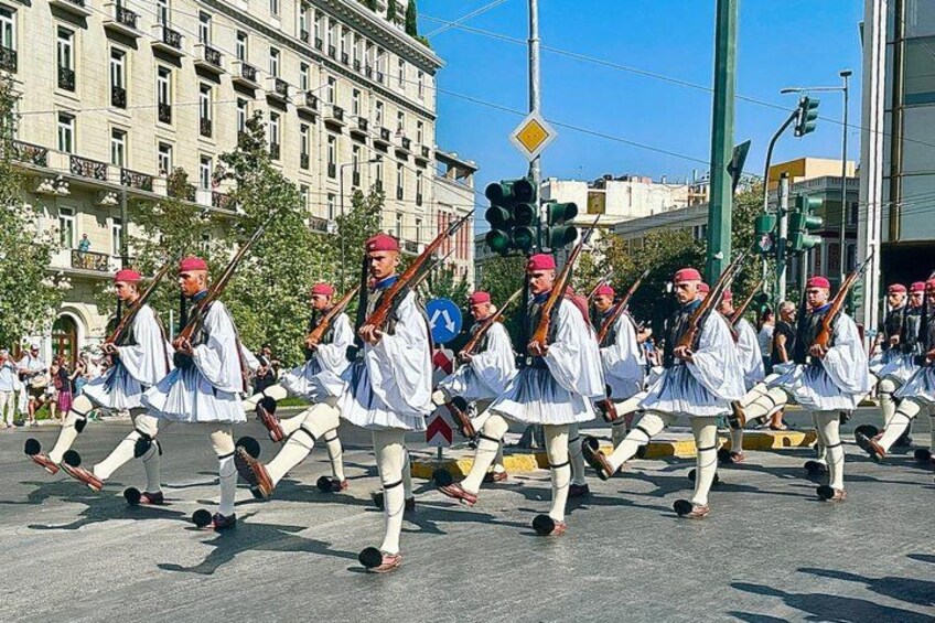 A group of people in white uniforms with red hats marching in formation. 4