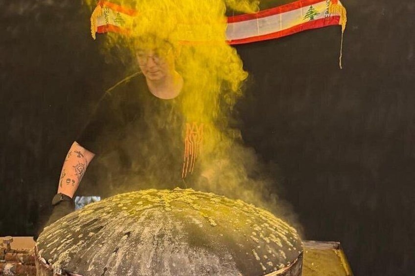 A person playing a drum with a yellow feathered headdress. 2