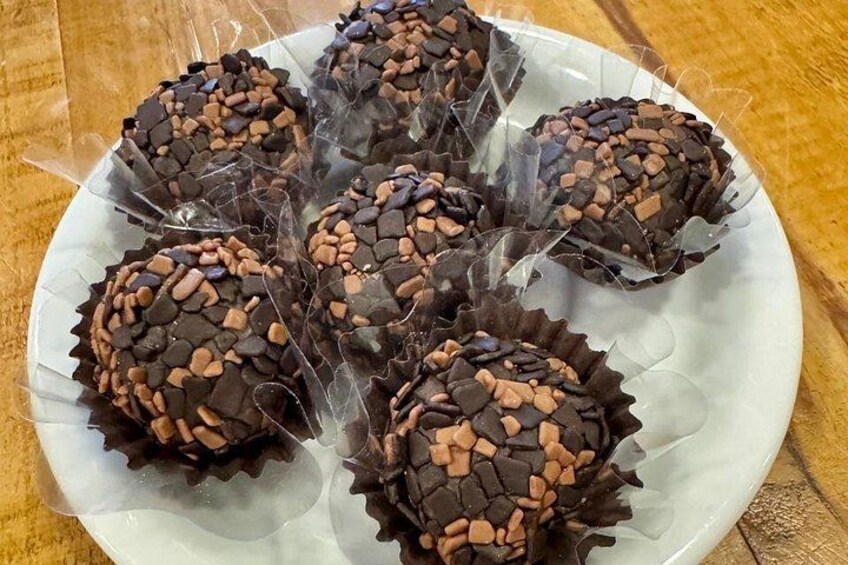 A plate of chocolate truffles with chocolate shavings. 2