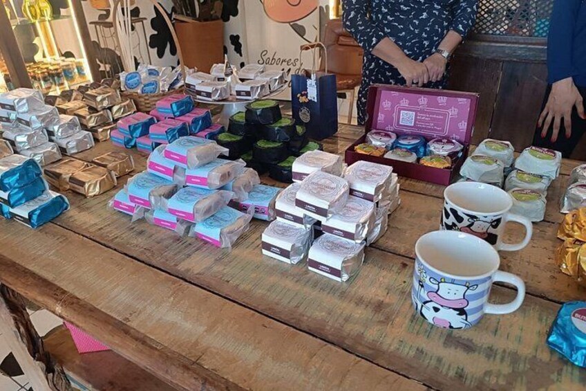 A wooden table with various packaged goods, including boxes and jars, and a mug with a cartoon character. 5