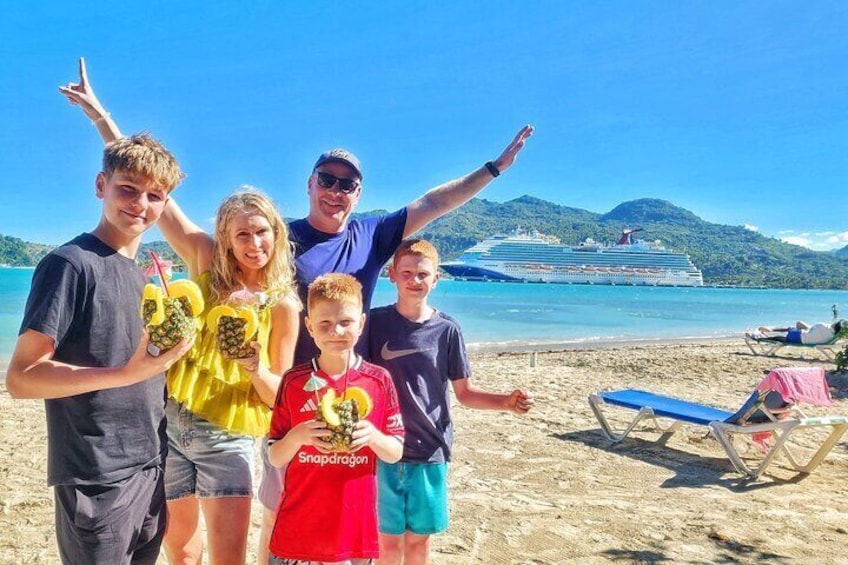 A family on a beach with a cruise ship in the background. 1