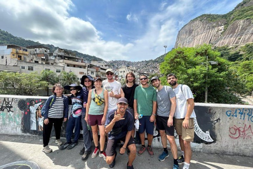 Un groupe de personnes posant sur un pont, avec une vue sur la ville et des montagnes en arrière-plan. 4