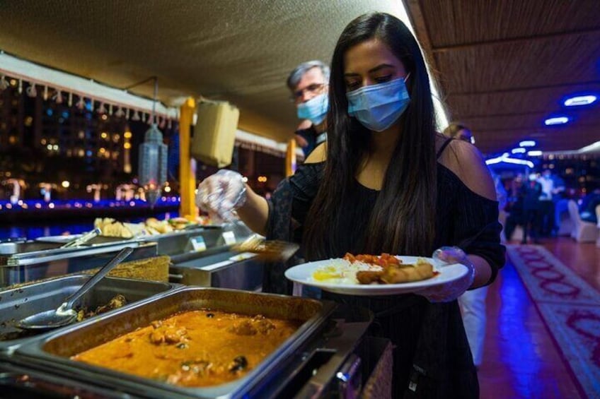 Una mesa de buffet con diversos platos y una persona sirviendo comida. 3
