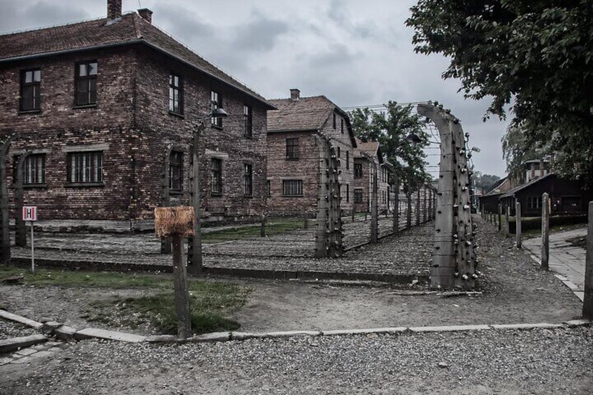 Un bâtiment historique doté d’une façade en briques, d’une clôture en métal et d’un poteau en bois sur lequel est fixée une plaque. 5