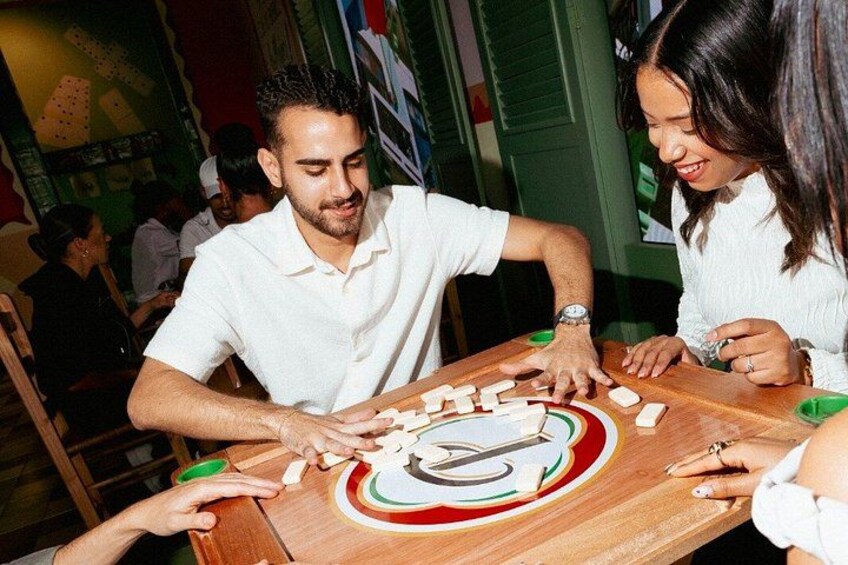 A group of people playing a board game at a wooden table. 3