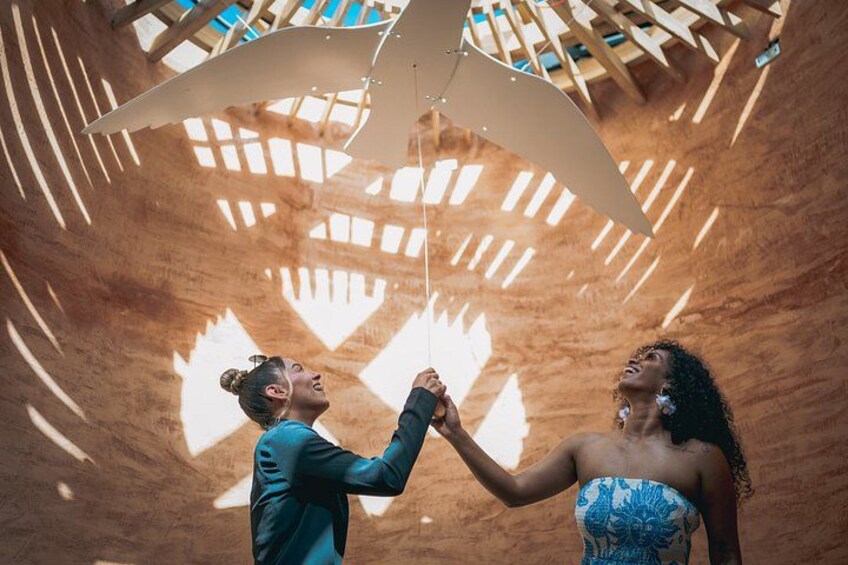 A couple dancing under a wooden structure with a geometric design. 5