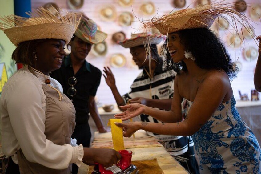 People wearing straw hats and a woman handing a yellow object to another person. 2