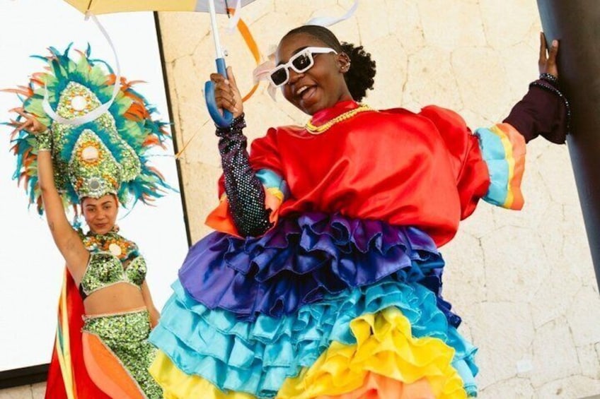 A person in a colorful, ruffled costume with a large, decorative headdress. 1