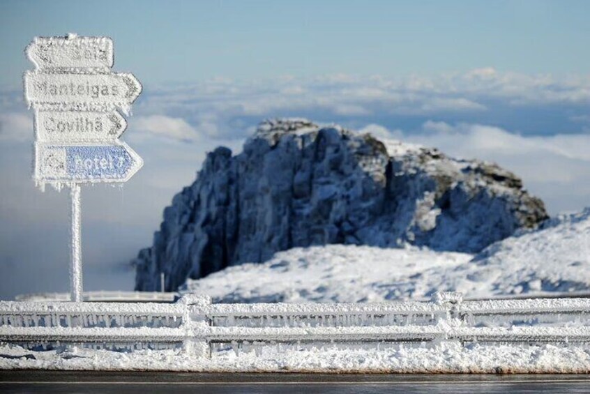 A frosted signpost with directions to Manteigas, Covilha, and a hotel. 3