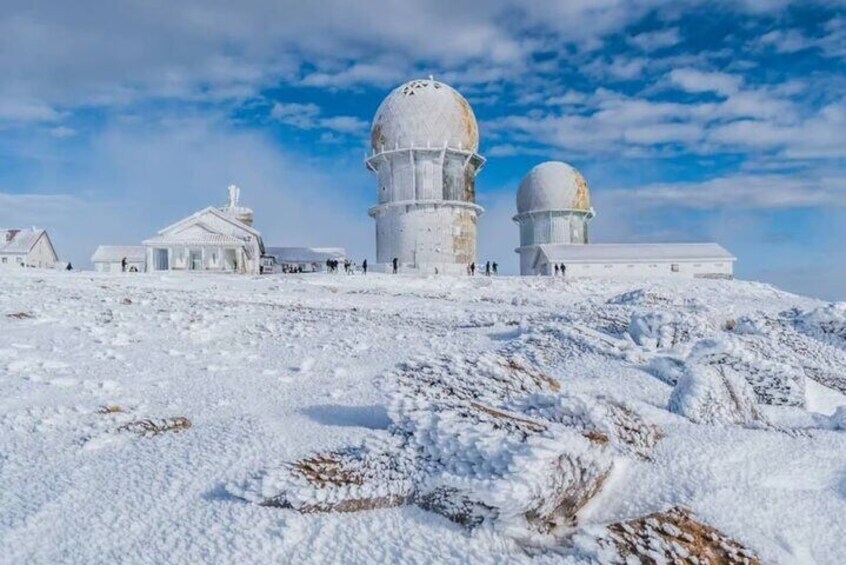 A snow-covered observatory with domed structures and a building with a dome. 1