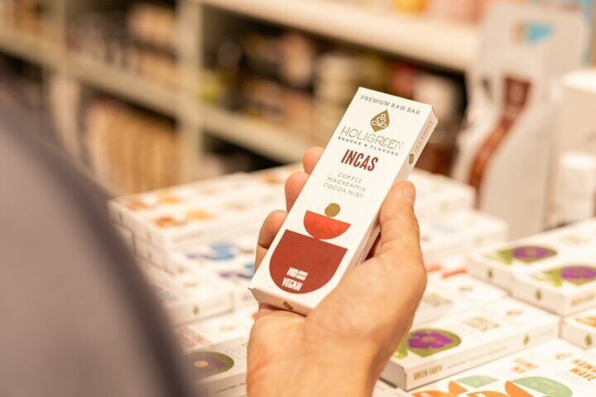 A hand holding a box of Holigreen Incas coffee macadamia cocoa. 1
