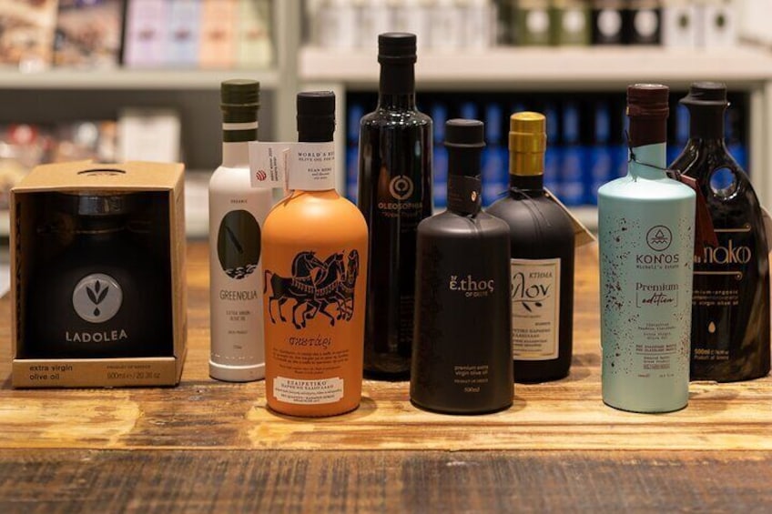 A variety of olive oil bottles and boxes on a wooden surface. 2