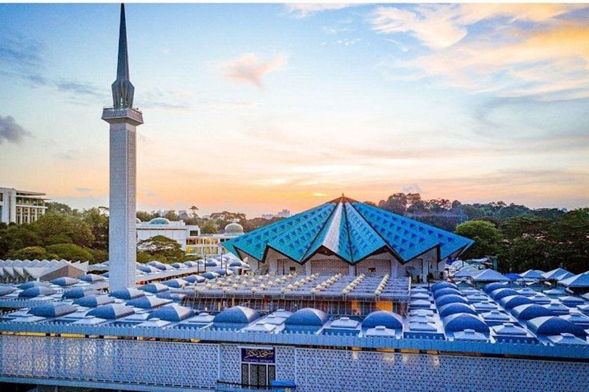 Eine Moschee mit einem hohen Minarett und einem Gebäude mit blauem Dach. 3