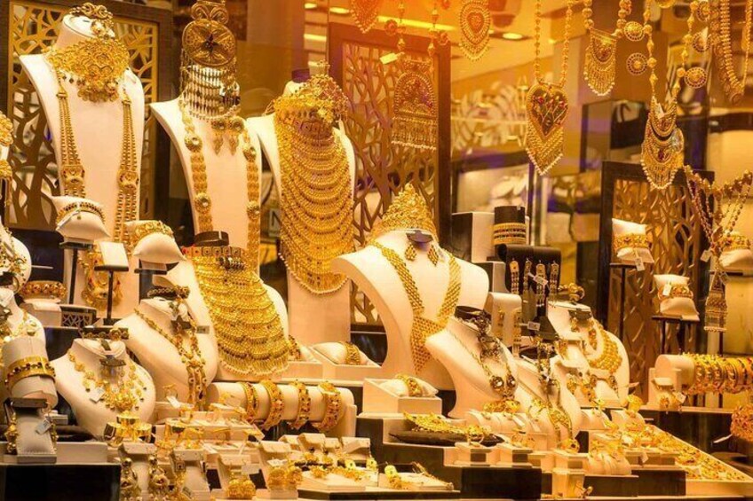 A jewelry store with various gold necklaces and bracelets displayed on mannequins. 2