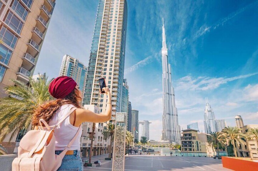A person taking a photo of the Burj Khalifa. 1