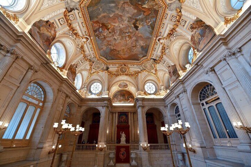 An ornate hall with a high ceiling, large windows, and chandeliers. 3
