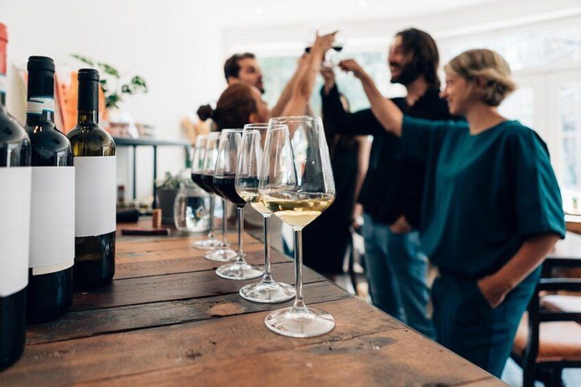 A wine tasting event with several wine bottles and glasses on a wooden table. 4