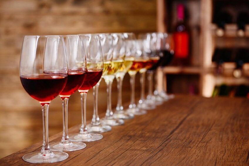 A row of wine glasses on a wooden table. 5