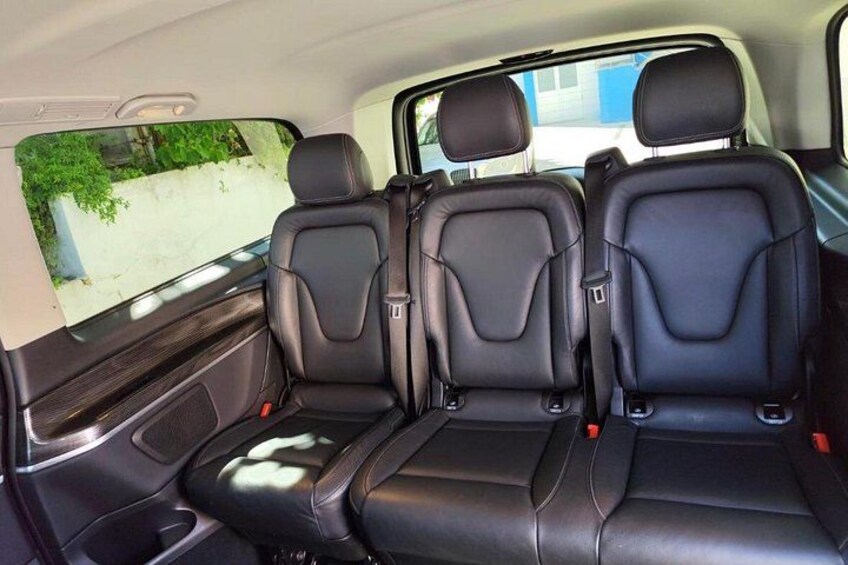 A car's interior with black leather seats and a sunroof. 2