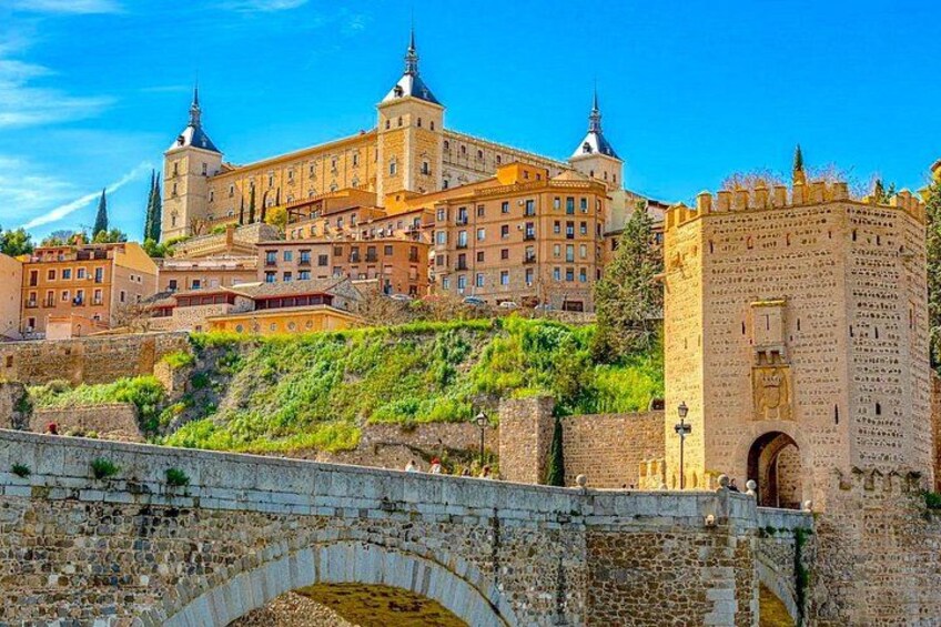 A historic building with multiple towers, a stone bridge, and a fortified tower. 4