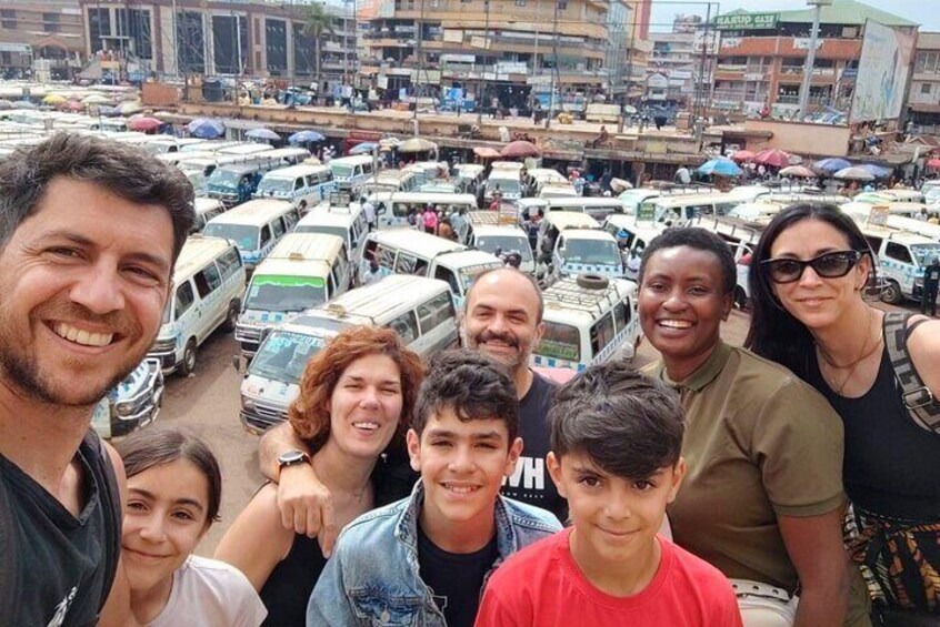 A group of people posing for a photo in a busy urban area with numerous vehicles and buildings in the background. 1