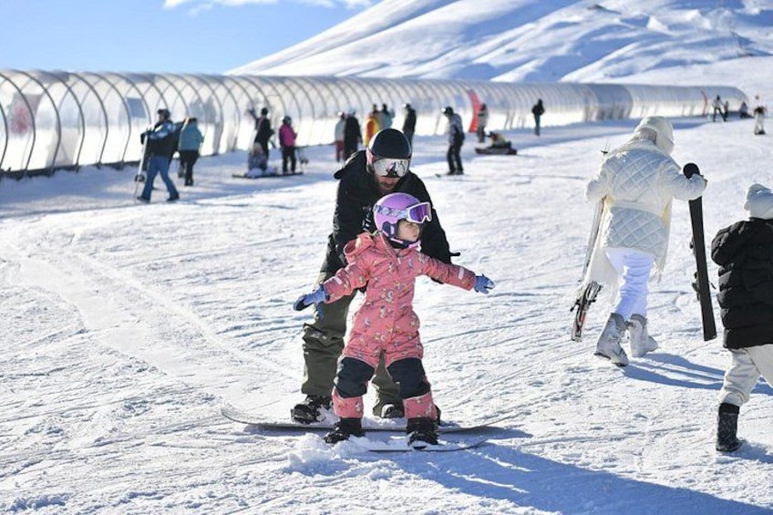 Una pista de esquí nevada con gente esquiando y practicando snowboard. 3