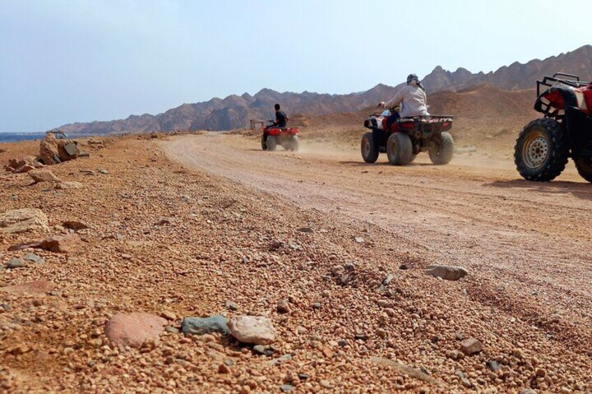 A rocky terrain with three off-road vehicles. 5