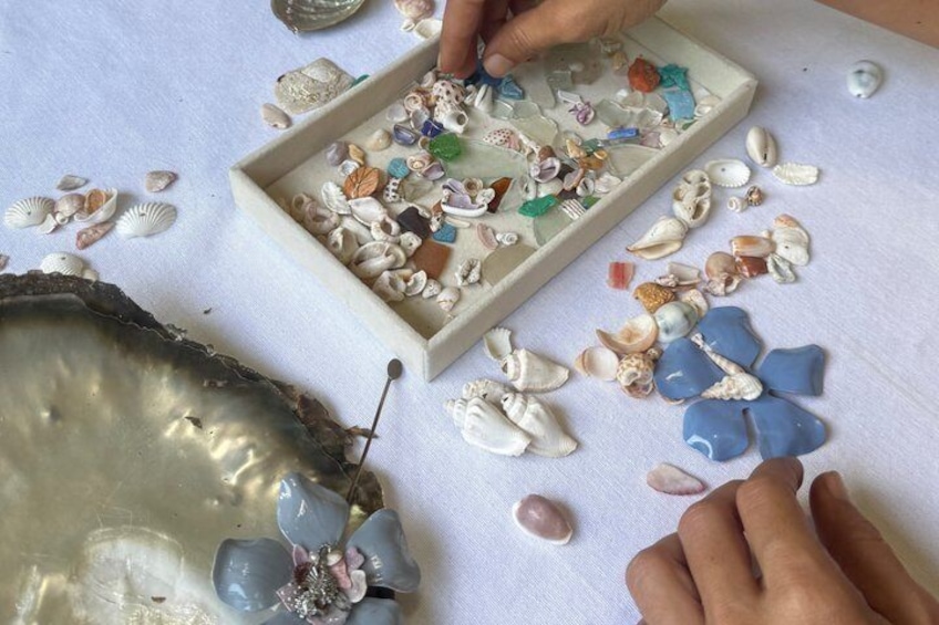 Hands sorting seashells and stones on a table. 4