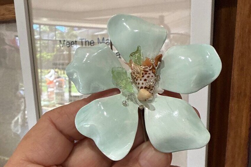 Een hand houdt een lichtgroene orchidee met een puntpatroon. 3
